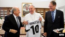 Papa Francisco (c), recibiendo una camiseta con su nombre y el número 10 de manos del presidente de la Federación Internacional de Fútbol Asociación (FIFA), Joseph Blatter (i), durante una audiencia privada en El Vaticano. 