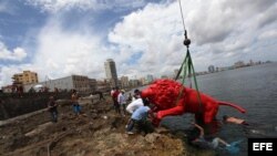 Un león rojo creado por Roberto Favelo para la obra "Garras en la piedra" instalado en los arrecifes del malecón de La Habana (Cuba).