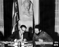 El presidente de Cuba, Osvaldo Dorticós (izda), firma la resolución del gobierno revolucionario que dispone la nacionalización de los bancos norteamericanos radicados en Cuba. A su lado, el primer ministro Fidel Castro (dcha).