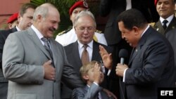 Hugo Chávez (d), saluda a Nikolai (c), hijo del presidente de Bielorusia, Alexander Lukashenko (c).