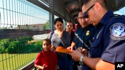 Funcionarios de Frontera procesan a una familia cubana en el Puente Internacional de Nuevo Laredo, Texas el 10 de julio de 2019. Foto AP /Salvador Gonzalez