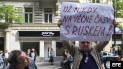 Un hombre observa una pancarta con las palabras "Nunca con Rusia" en manos de un checo durante una ceremonia para conmemorar el 46º aniversario desde la ocupación soviética de la antigua Checoslovaquia en 1968, hoy, jueves 21 de agosto de 2014. 