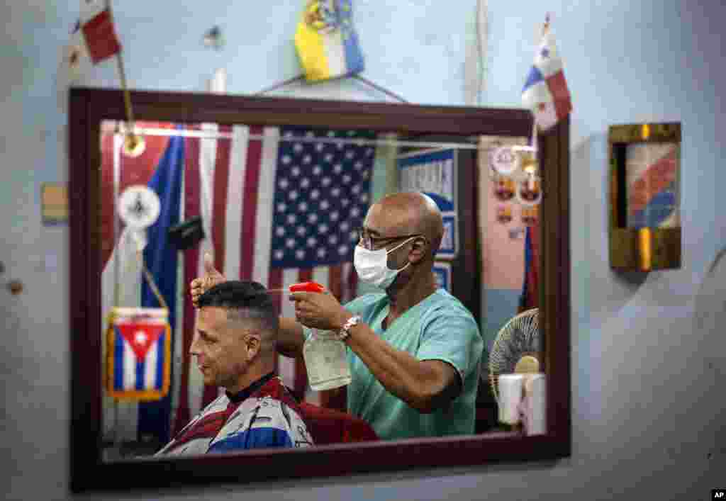 Un empleado en una barbería privada usa máscara de protección contra el coronavirus en La Habana. (AP/Ramon Espinosa)