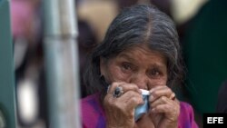 Una mujer espera los cuerpos de sus familiares, sepultados por un alud, en la morgue habilitada en Santa Catarina Pinula, Guatemala.