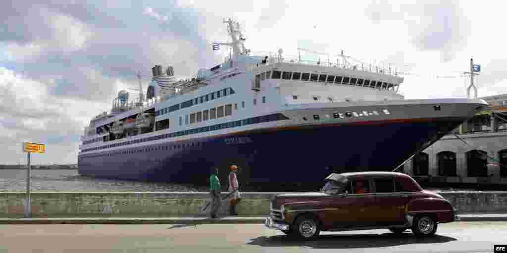 Un viejo auto pasa hoy, sábado 29 de noviembre de 2014, junto al crucero académico "M.V. Explorer", que permanece fondeado en La Habana (Cuba).