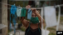 Una mujer del Mariel tiende nasobucos de tela el jueves luego de lavarlos (Foto: Yamil Lage/AFP).