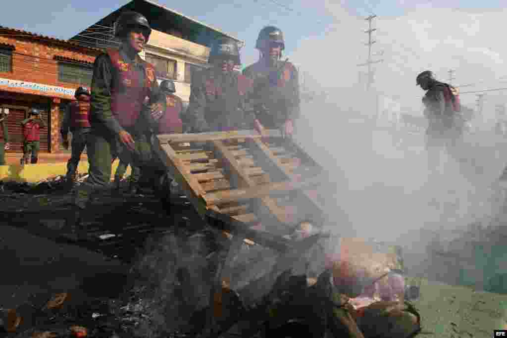 Miembros de la Guardia Nacional Bolivariana (GNB) retiran escombros el miércoles 19 de febrero de 2014, tras las protestas registradas en el sector El Prebo de Valencia (Venezuela). 