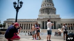 Turistas estadounidenses posan frente al Capitolio Nacional.