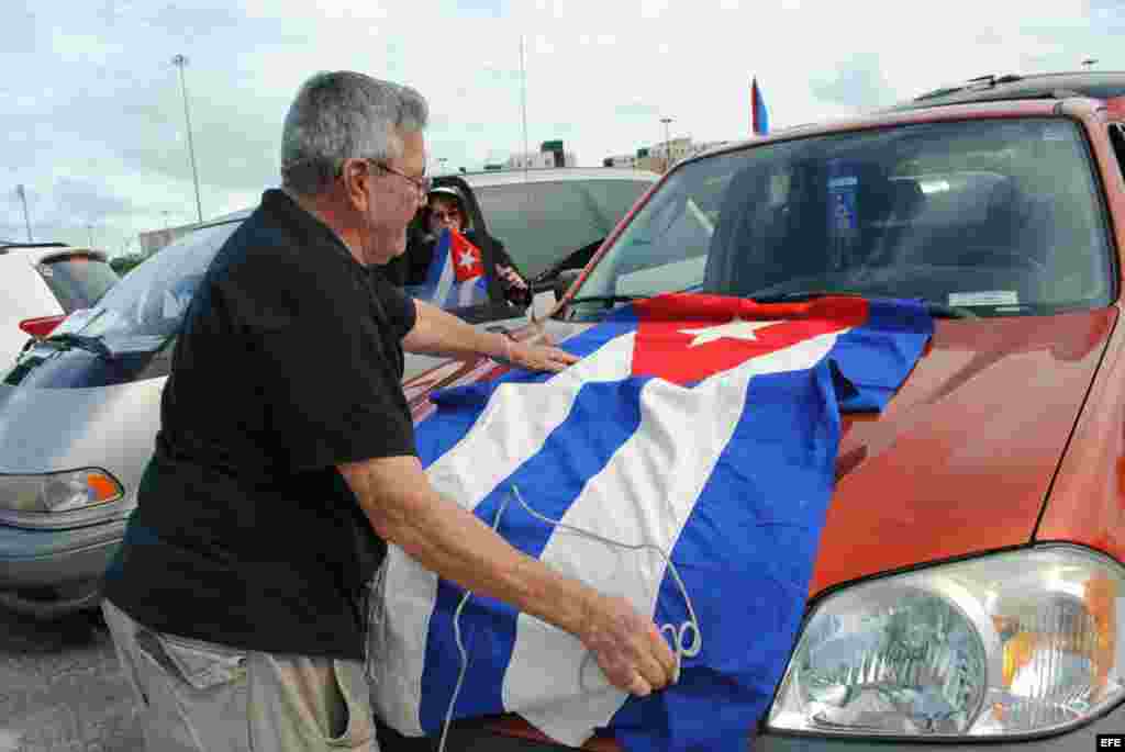 Un hombre coloca una bandera de cuba en su vehículo hoy, sábado 6 de junio de 2015, cuando unos 300 exiliados cubanos se concentraron en Miami.