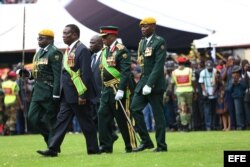 Mnangagwa (2i), camina junto a varios oficiales durante su ceremonia de juramento oficial.