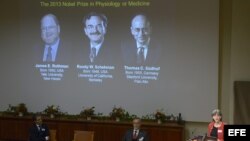 Una pantalla muestra las fotografías de los científicos estadounidenses (de izda a dcha) Randy W. Schekman y James E. Rothman así como la del alemán Thomas C. Südhof mientras se anuncian sus nombres como ganadores del Nobel de Medicina 2013. 