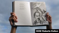Un cubano alza un libro con la imagen y versos del apóstol José Martí. (Foto: Roberto Koltun/OCB/Archivo)