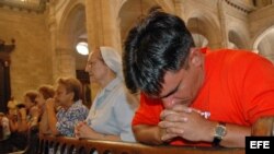Varias personas participan en una misa en una iglesia católica en La Habana.