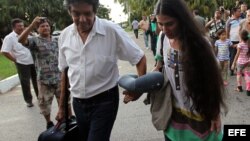 La bloguera cubana Yoani Sánchez (c), creadora del blog "Generación Y", habla con su esposo, el opositor Rainaldo Escobar (i), y su hijo, Teo (d), a su llegada a La Habana (Cuba) hoy, jueves 30 de mayo de 2013, luego de una gira de más de 100 días por var