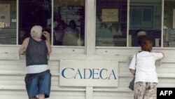 Cubanos cambian dólares estadounidenses por pesos convertibles en una Casa de Cambio (CADECA). (Archivo/Adalberto ROQUE/AFP)
