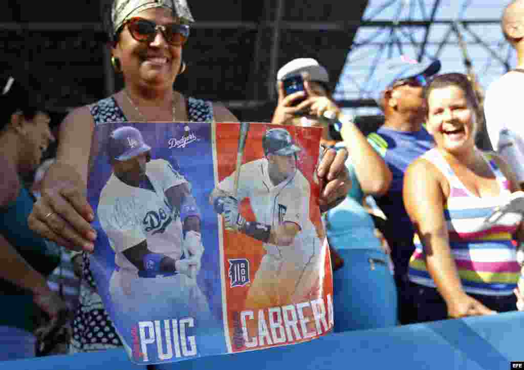 Una aficionada muestra un cartel de los beisbolistas Manuel Pui y Miguel Cabrera durante una clase práctica de beisbolistas de Grandes Ligas.