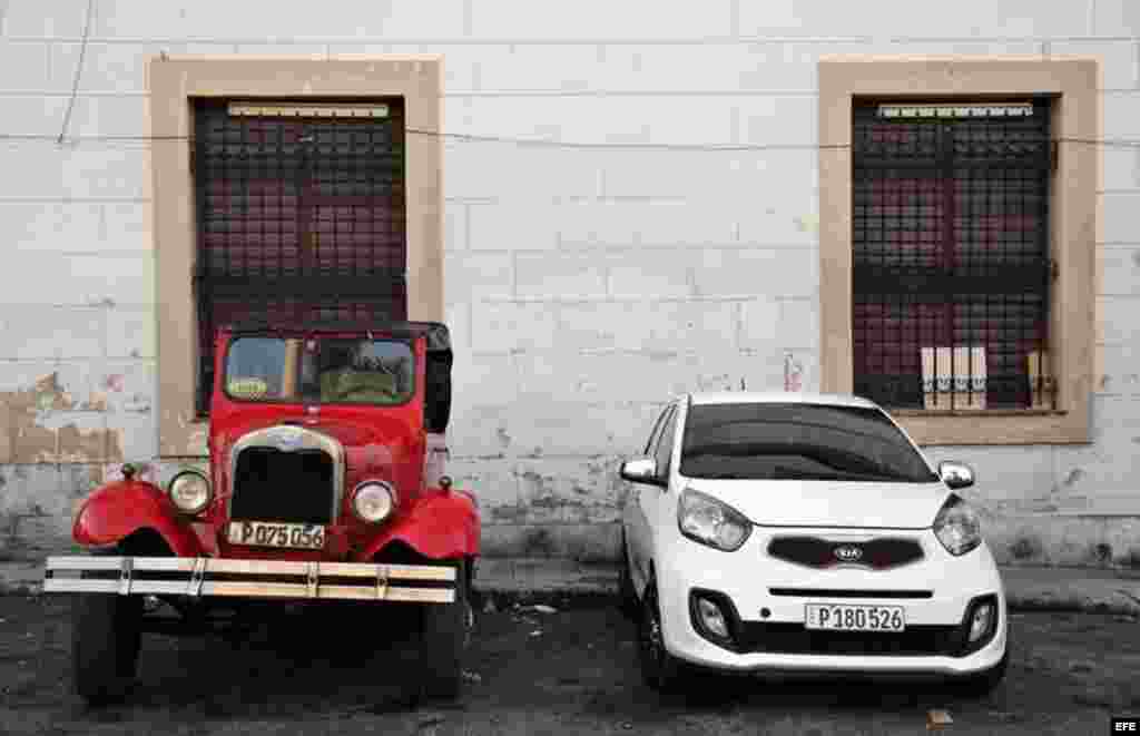 Dos vehículos uno antiguo y uno moderno permanecen estacionados en una calle de La Habana (Cuba), este viernes, 20 de enero de 2017, día en que Donald Trump asume la presidencia de EEUU. &nbsp;