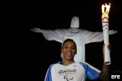 La medallista olímpica Rafaela Silva, carga la antorcha Paralímpica Río 2016, con el Cristo Redentor al fondo.