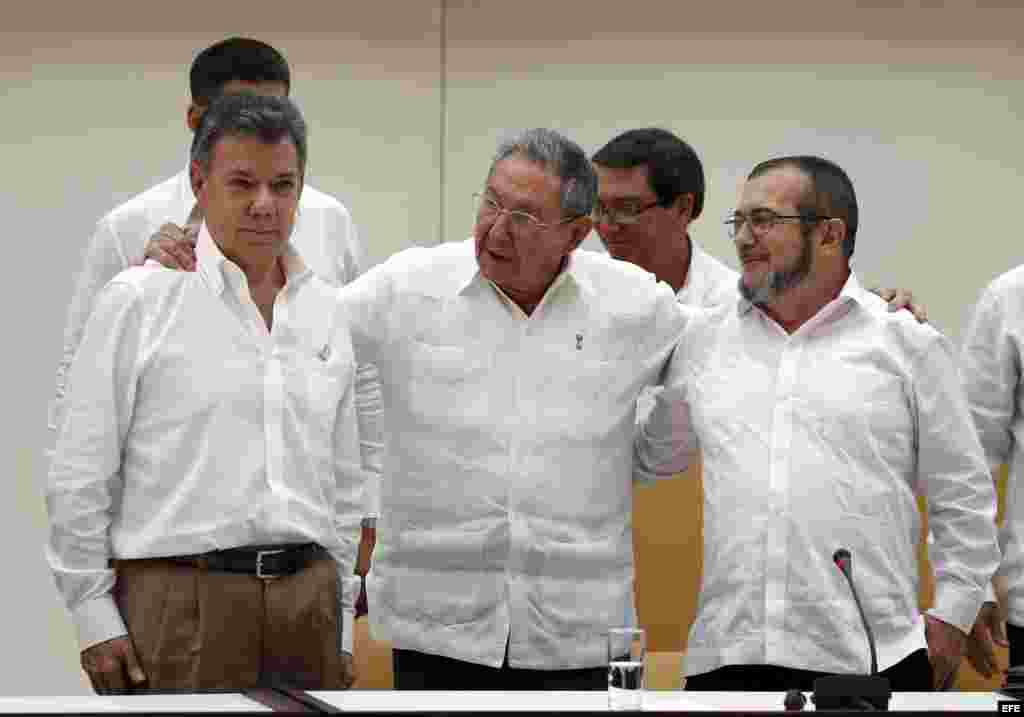 Raúl Castro abraza a Juan Manuel Santos y al líder de las FARC, Rodrigo Londoño, alias "Timochenko", tras la firma del acuerdo.
