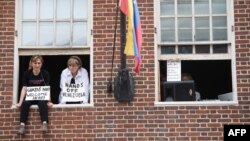 Dos manifestantes de Code Pink ocupan la embajada de Venezuela en Washington DC. Luego fueron arrestadas por la policía. (AFP).