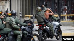 Guardia nacional conduce a uno de los detenidos en las protestas contra Nicolás Maduro el 23 de enero de 2019.