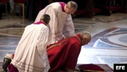 El papa Francisco es ayudado al levantarse durante la misa de Viernes Santo en la Basílica de San Pedro en el Vaticano.
