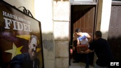 Dos hombres cargan cajas de cerveza en un restaurante privado un día después de la inhumación de las cenizas de Fidel Castro.