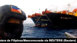 Personal de la Guardia Costera de Filipinas observan barcos chinos con presuntos milicianos en el Mar de la China Meridional a mediados de abril de 2021. (Guardia Costera de Filipinas/Mancomunada via REUTERS).