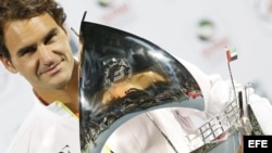 Federer sostiene el trofeo que le entregaron tras ganar por séptima vez el torneo de tenis de Dubai. 