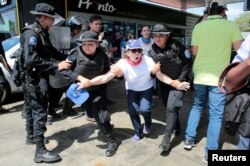 Policías antidisturbios detienen a una manifestante contra el régimen de Daniel Ortega en Nicaragua.