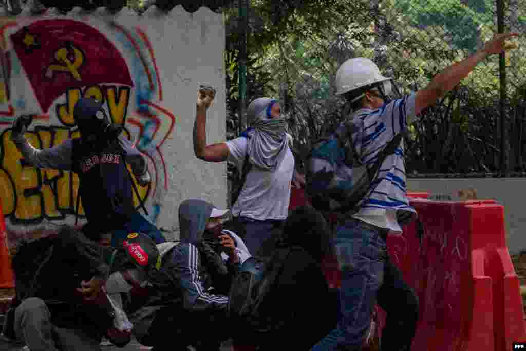 Manifestantes se enfrentan con policías antimotines hoy, jueves 4 de mayo de 2017, en Caracas (Venezuela). Los cuerpos de seguridad dispersaron con gases lacrimógenos la manifestación de estudiantes que se concentró en la Universidad Central de Venezuela 