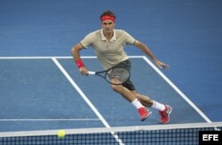 Federer devuelve la bola al australiano Matosevic durante el partido que enfrentó a ambos en el torneo de Brisbane (Australia) hoy, viernes 3 de enero de 2014.