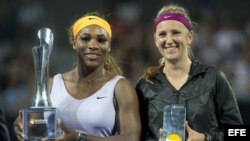 Serena Williams (i) y Victoria Azarenka (d) posan con sus trofeos.