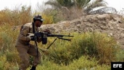 Integrantes de la milicia chií iraquí "Brigadas de Paz", que voluntariamente combaten al lado de las fuerzas iraquíes contra el grupo Estado Islámico (EI), combaten, al tomar posición en la ciudad Jurf al-Sakher, al sur de Bagdad (Irak). 
