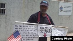 Llorente, con los carteles, listo para la protesta frente a la embajada de Cuba en Guyana. 