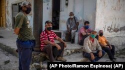 Trabajadores esperan a las afueras de un central azucarero. (AP/Ramon Espinosa)