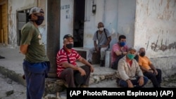 Trabajadores esperan a las afueras de un central azucarero que paró debido a la falta de combustible. (AP/Ramón Espinosa).