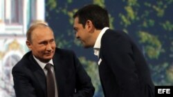 El primer ministro griego, Alexis Tsipras (dcha), saluda al presidente ruso, Vladímir Putin, antes de participar en una sesión plenaria del Foro Económico Internacional de San Petersburgo (Rusia) hoy, viernes 19 de junio de 2015.