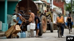 FOTO ARCHIVO. Una pipa abastece agua a un grupo de cubanos. (Yamil Lage/AFP).
