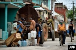 FOTO ARCHIVO. Vecinos recogen agua de una pipa. Aguas de La Habana dijo que las personas que se abastecen de esta manera pueden estar hasta 17 días esperando el camión cisterna. (Yamil Lage/AFP).