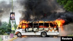 Un autobús en llamas. Escena de un enfrentamiento entre narcos y federales en México. 