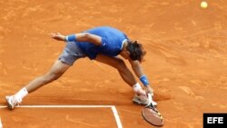El tenista español Rafael Nadal se estira para intentar devolver una bola durante el partido de cuartos de final del torneo de Montecarlo que disputó contra su compatriota David Ferrer.