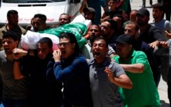 Dolientes cantan consignas islámicas mientras llevan el cuerpo de Awad Abu Selmiya, durante un funeral de trece militantes de Hamas frente a una mezquita en la ciudad de Gaza, el jueves 13 de mayo de 2021. Foto: AP/Adel Hana.