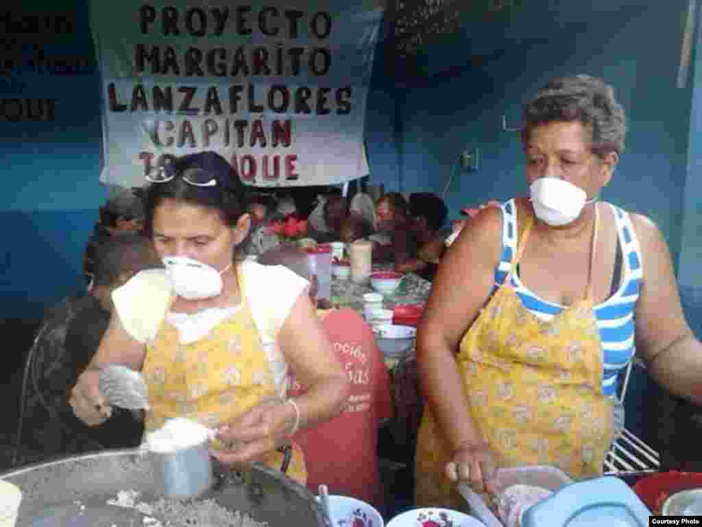 Dos activistas brindan ayuda a necesitados en el Proyecto "Capitan Tondique", Colón, Matanzas.