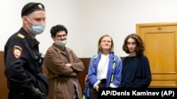 Las autoridades rusas rodean a los estudiantes de periodismo, de izq. a der., Armen Aramyan, Natalya Tyshkevich y Alla Gutnikova. (Foto AP/Denis Kaminev)