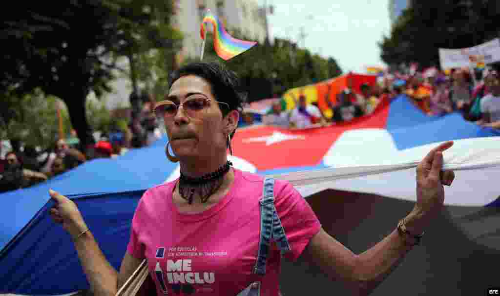 Una mujer trans sostiene una bandera cubana gigante durante una "conga" contra la homofobia y la transfobia en La Habana.