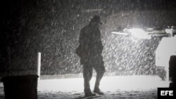 Un peatón camina el miércoles 7 de noviembre de 2012, por el distrito financiero de Manhattan, en Nueva York (EEUU), durante una tormenta de nieve. 