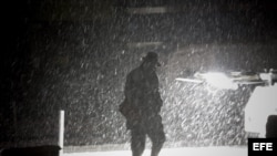 Un peatón camina el miércoles 7 de noviembre de 2012, por el distrito financiero de Manhattan, en Nueva York (EEUU), durante una tormenta de nieve. 
