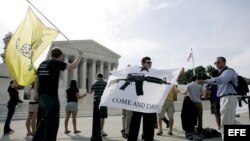 Archivo - Manifestantes pro-armas muestran banderas frente al Tribunal Supremo de EE. UU., en Washington D.C., el 26 de junio de 2008. El Supremo reconoció ese día el derecho de los estadounidenses a poseer armas de fuego