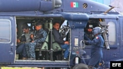 Militares mexicanos conducen en un helicóptero al máximo dirigente del cártel de Sinaloa, Joaquín "El Chapo" Guzmán (c), quien fuera detenido en el puerto turístico de Mazatlán (México), en la madrugada del sábado 22 de febrero de 2014.
